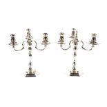 A pair of cast silver candelabra, having detachable three light tops on baluster columns and