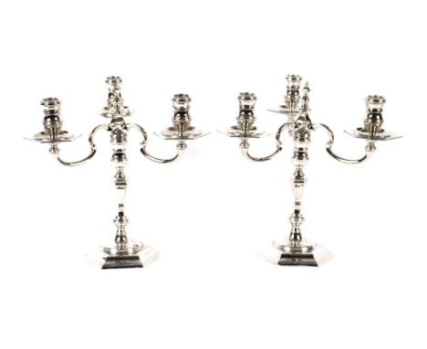 A pair of cast silver candelabra,&nbsp;having detachable three light tops on baluster columns and octagonal bases, London 195