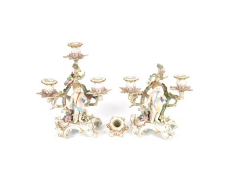 A pair of 19th Century German porcelain three light candelabra,&nbsp;with floral encrusted and cherub decoration, 27cm high, 