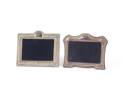 A silver mounted easel photograph frame,&nbsp;of cartouche shape; and another with raised foliate decoration&nbsp;