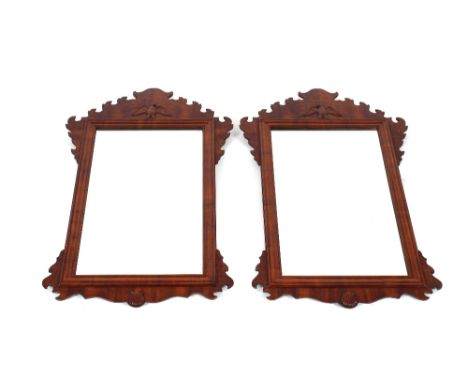 A pair of Chippendale style walnut wall mirrors, with fret carved decoration and moulded cushion frieze, shell and bird motif