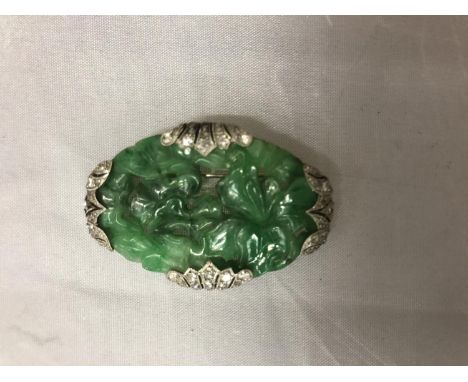 A WHITE METAL AND JADE BROOCH 