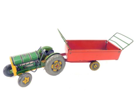 A Mettoy green tin plate tractor, 19cm long, together with a trailer.