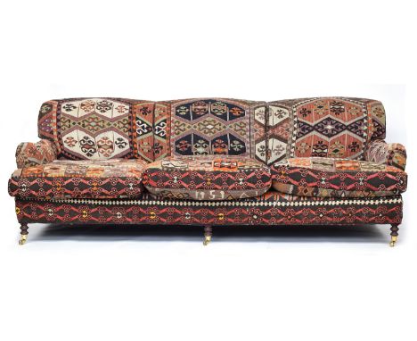 A substantial kilim upholstered George Smith three seater sofa, on turned legs with brass caps and casters, 246cm wide, appro