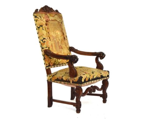 A substantial Continental carved throne chair, carved rail over tapestry upholstered seat and back, the arms with lion mask t