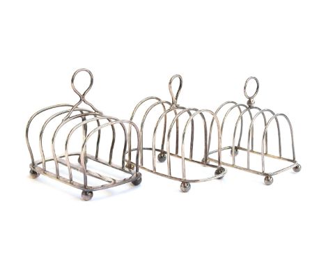 Three silver toast racks: the largest, four division, by Mappin &amp; Webb, London 1919; the other two Birmingham 1923, the s