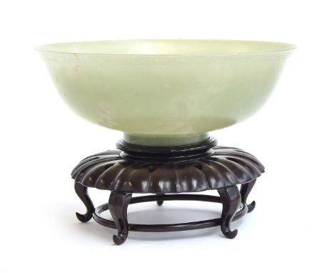 A very large Chinese jade bowl, with carved Greek key border, 29cm diameter and 10.5cm high, on a carved hardwood stand, 9.5c