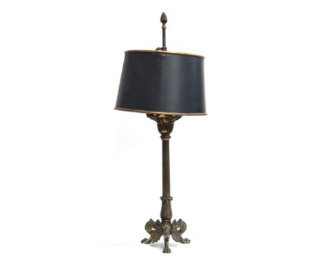 A late 19th century brass oil lamp converted for electrical use, with green tole shade, on three paw feet with shell motifs, 