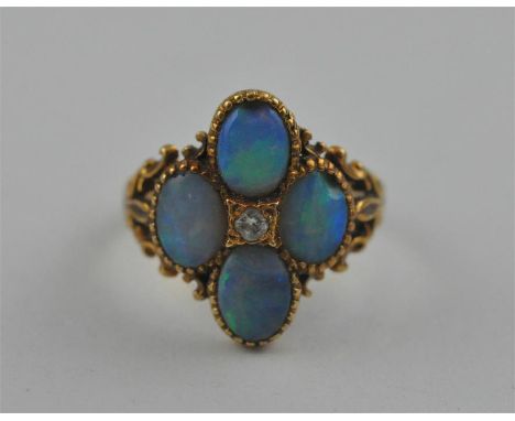 An precious opal and diamond ring, the hallmarked 18 carat yellow gold quadrefoil form ring set four ovoid cabochon precious 