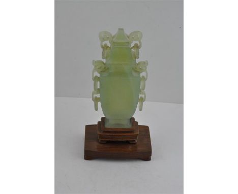 A Chinese jade vase, 20th century, in the archaic style, having triple pairs of pierced and carved handles with rings to each