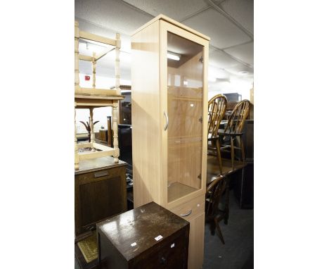 A TALL, NARROW LIGHT OAK DISPLAY CABINET WITH DRAWER AND CUPBOARD BELOW, 20" WIDE 