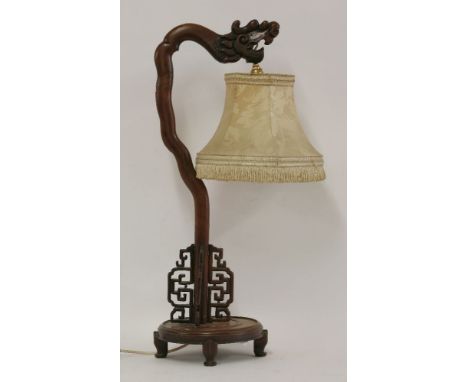 An early 20th century Chinese hardwood table lamp, carved with a dragon head, with fret cut panels, 70cm high