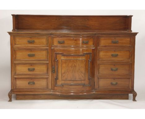 An Edwardian walnut bow front sideboard, with a gallery over drawers and a cupboard
