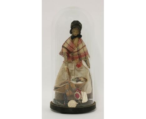 A 19th century carved wooden pedlar doll, with wax face, dressed in Victorian clothing, black bonnet, dress and red cloak, ca