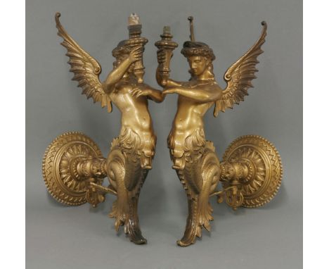A pair of Victorian cast wall light brackets, modelled as winged mermaids/muses, holding torches, registration marks to waist