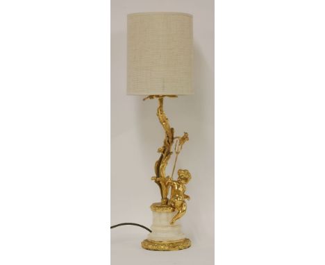 An ormolu and marble table lamp, of a cherub holding a trident