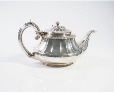 A GEORGE IV SILVER TEAPOTThe body with partly fluted decoration below a foliate band, the hinged lid with a flower finial, wi