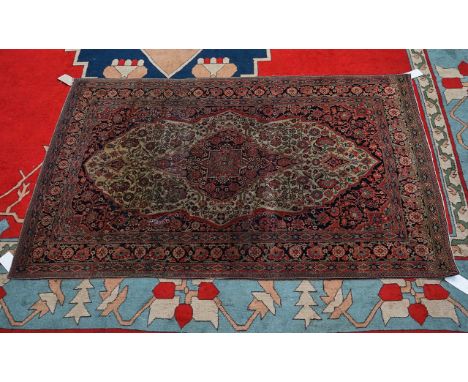 A KASHAN MOHTASSHAN, PERSIANThe ivory field with a dark indigo and madder medallion, a dark indigo surround all with abundant