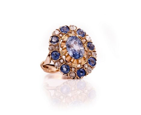 A SAPPHIRE AND DIAMOND OVAL CLUSTER RINGClaw set with the principal oval cut sapphire in a surround of circular cut sapphires