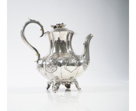 A WILLIAM IV SILVER HOT WATER JUGOf fluted baluster form, decorated with floral reserves, raised on four scroll and scalloped