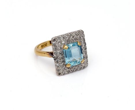 A GOLD, AQUAMARINE AND DIAMOND RECTANGULAR CLUSTER RINGClaw set with a cut cornered rectangular step cut aquamarine in a two 