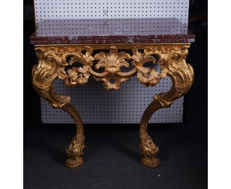 A 19TH CENTURY CONSOLE TABLEThe double laminated rectangular marble top over a carved and pierced gilt base, on dual S-scroll