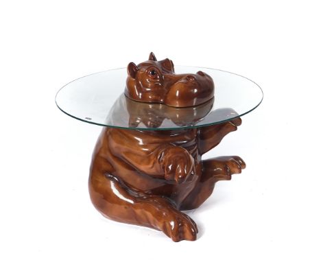 A MODERN CIRCULAR GLASS OCCASIONAL TABLEWith seated ceramic hippopotamus support, 66cm diameter; 53cm high