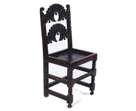 A CHARLES II OAK SINGLE CHAIRWith double carved arch back over solid seat on bobbin turned supports the front rail stamped IB