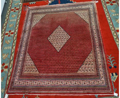 A SERRABAND CARPET, PERSIANThe madder field, with a diamond to centre matching spandrels, all with minor Boteh's and ivory co