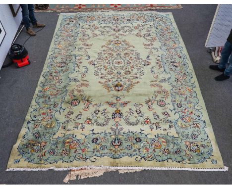 A KASHAN CARPET, PERSIANThe pale green field with delicate floral spray medallion and spandrels, complimentary border. 417cm 