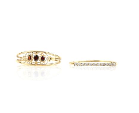 Two gold bangles, including an illusion set diamond clasp bangle, inside diameter 63 x 55mm, and a garnet set torque bangle, 