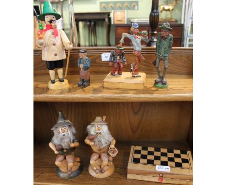 A SELECTION OF CARVED WOODEN FIGURES depicting three German smoking men, three comical figures &amp; a small sized chess set 