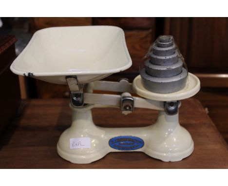 A buttermilk finished vintage set of pan scales, together with a series of weights 