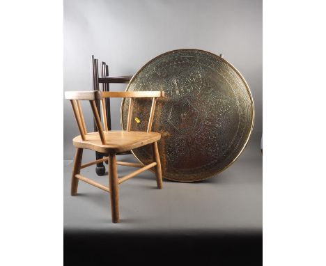 A circular brass topped folding table, a child's elm and beech stick back chair, and a carved oak spinning stool