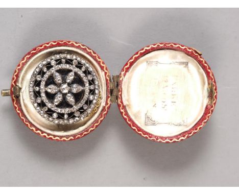 An early 19th century yellow metal circular memento brooch set old cut diamonds over black enamel, 25mm dia, 10.1g, in red mo