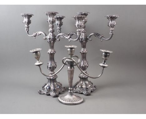 A pair of silver plated three-light candlesticks of Rococo design, 17" high, and a smaller candlestick of Adam design, 11" hi