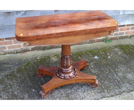 A 19th century figured mahogany fold-over top card table, on acanthus carved column, quadruple base and scroll feet, 36" wide