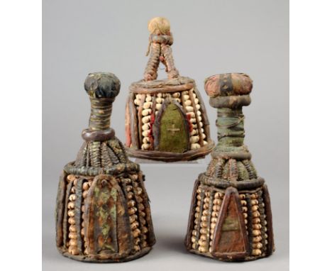 Three Yoruba Ibori Nigeria cowrie shells, cloth and hide, of conical form with spherical finials, symbolising the inner head,