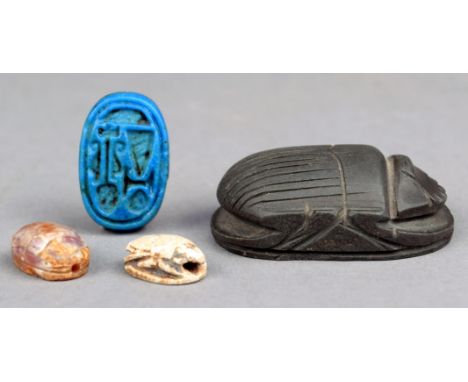 An Egyptian heart scarab green serpentine, uninscribed, 4.5cm long, a blue faience ring bezel with official symbols, an ameth