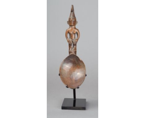 A Ifugao spoon Philippines wood with a standing female handle wearing a double circle headdress, 18.5cm high, on a stand. (2)