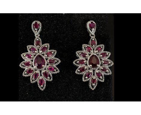 Ruby Ovoid Cluster Drop Earrings, each earring having a pear cut ruby surrounded by marquise cut rubies in a milgrain platinu