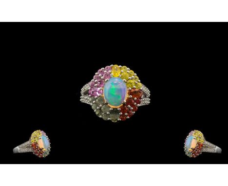 Opal and Multi Colours of Sapphire Ring, an opal cabochon of 1.5cts, with a wide frame of 3cts of round cut 'rainbow' or 'fan