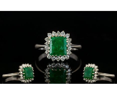 18ct White Gold Attractive Emerald And Diamond Cluster Ring Fully hallmarked, the central step cut emerald of good colour, su