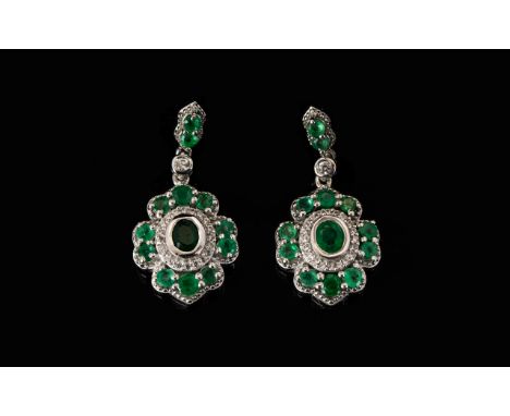 Emerald and Zircon Drop Earrings, each pendant drop having an oval cut emerald, bezel set, initially framed with round cut na