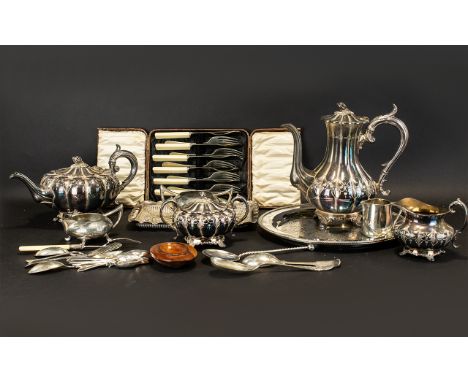 A Mixed Collection Of Plated Metal Ware To include a four piece tea service, embossed trays, loose cutlery, brush, serving sp