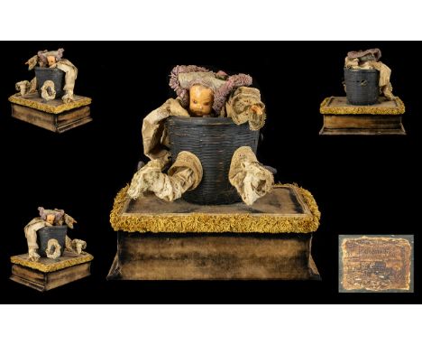 An Early 20th Century Scratch Built Antique Style Musical Automaton In the form of a macabre baby doll in basket; clothed in 