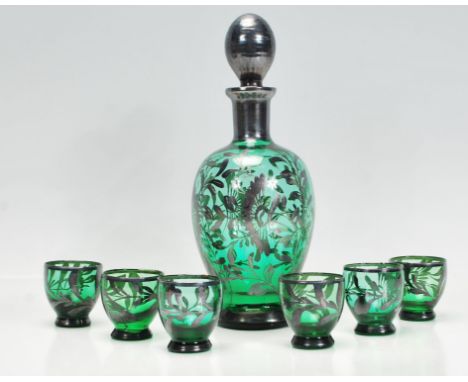 A Bohemian green glass decanter and stopper overlaid with silver white metal together with six matching glasses.&nbsp; Measur