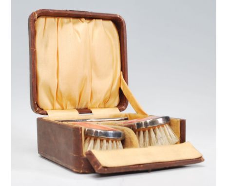 A silver plated and pink&nbsp; guilloche enamel cased three-piece dressing table / brush set consisting of two matching hair 