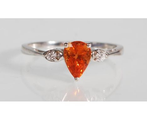 A stamped 9ct white gold ring set with a teardrop cut orange stone flanked by two round cut white stones. Assay marked Birmin