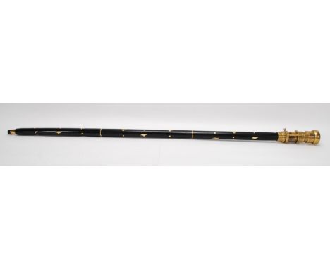 A Novelty walking stick / cane mounted with a metamorphic brass monocular and small clock atop with Roman numeral chapter rin